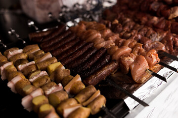 Meat and potatoes with lard on skewer, cooked on the grill, fragrant atmosphere of street food.