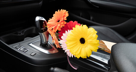 Gerberas in the interior of the car on the gearbox