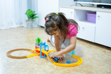 baby game. Little clever caucasian child playing colorful toy railway and train for early...