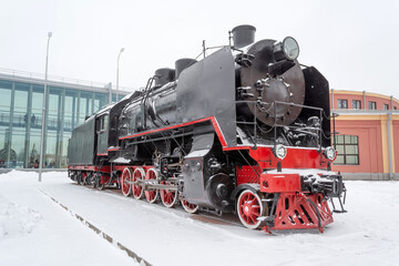Fototapeta premium Steam locomotive of black color on the railway road in winter.