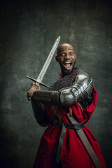 Half-length portrait of dark skinned man, medieval warrior or knight wearing armour shouting...