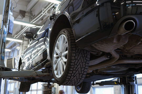 Moscow Russia - January 2022: Modern luxury car in a car service on a lift. Service, repair, diagnostics. Selected focus.