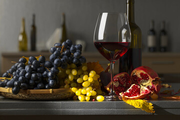 Grapes, pomegranate, and a glass of wine.