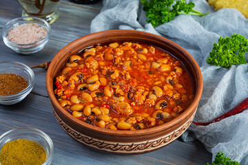 Chili con carne in a bowl on wooden background. Mexican cuisine