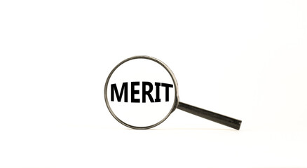 Merit symbol. Magnifying glass with word merit on a beautiful white table, white background. Businessman hand. Business and merit concept, copy space.
