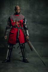 Vintage style portrait of brutal dark skinned man, medieval warrior or knight with wounded face...