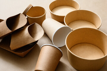 Paper cups and various food containers around. Eco-friendly tableware and items for food delivery and storage. Selective focus on paper cup.