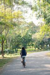 asian woman biking bicycle at park