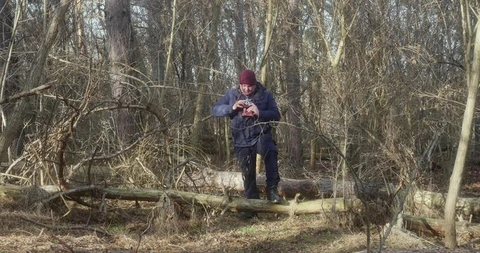 man takes pictures on an old film camera in the forest