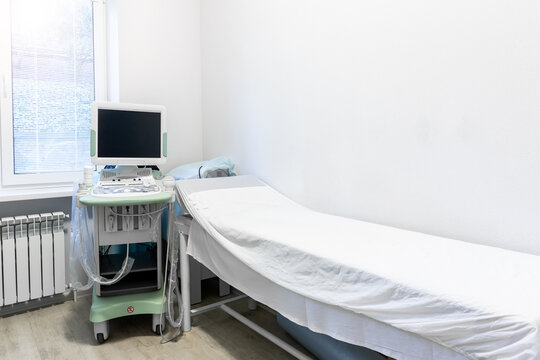 Doctor's office with couch and diagnosis tools. Close-up of ultrasound machine in clinic. Modern hospital with high technology equipment. Health care, diagnostic and disease prevention concept