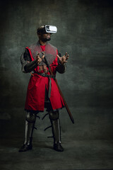 Modern gadgets. One dark skinned man, medieval warrior or knight using VR headsets isolated over...