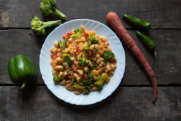 Popular Italian food macaroni pasta cooked in sauce served in a white plate.	