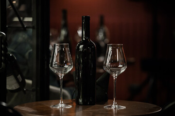 wine glasses and bottles of wine in the entourage of the wine bar in the evening