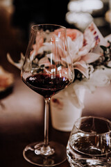 a wine glass and a delicate bouquet are a compliment. photography in a dark key.