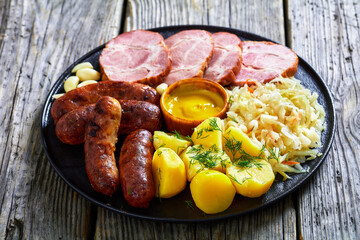 bratwurst, pork, potatoes, sauerkraut on a plate