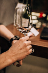 Fototapeta na wymiar wine glass in the male sommelier's hand. Wine bar or winery. degustation.