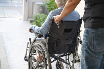 Obraz premium Caregiver help and care Asian senior or elderly old lady woman patient sitting on wheelchair at nursing hospital ward, healthy strong medical concept