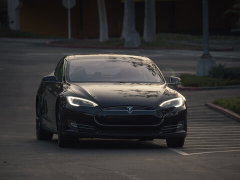 LOS ANGELES - December 2021: TESLA Model S electric car on parking lot with headlights turned on.