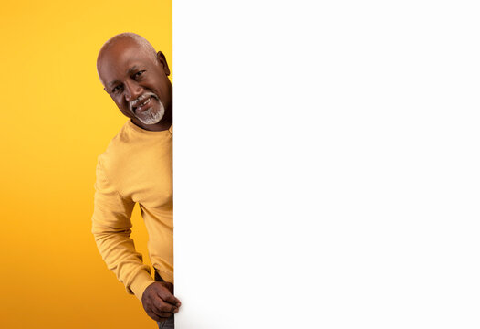 Senior African American Man Looking Out From Behind Big White Paper Poster, Advertising Your Service, Mockup