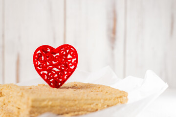 Red heart on Napoleon cake. Sweet dessert for Valentine's day. White background.