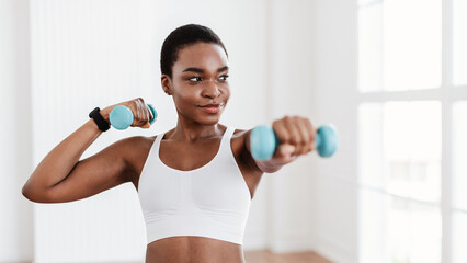 Sporty Black Lady Exercising With Two Dumbbells And Posing