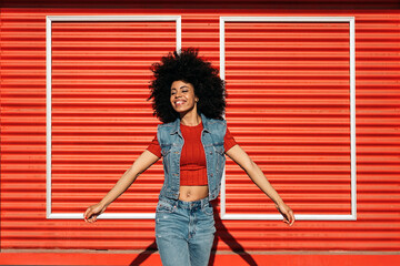 Young afro woman posing over a red background