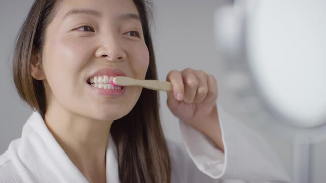 Close Up Shot of a Woman Brushing Teeth and Smiling