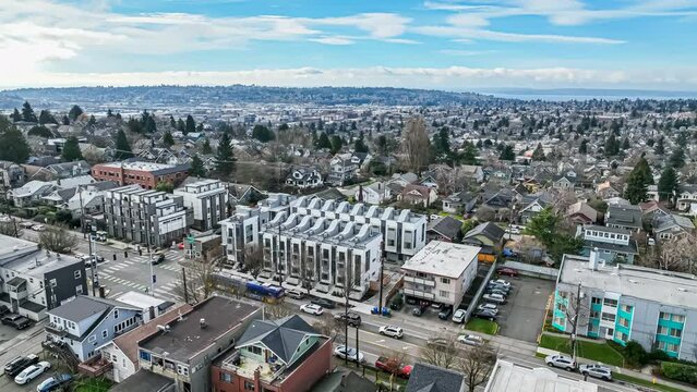 Aerial view of a Seattle area neighborhood, circling to approach a row of newly constructed townhomes