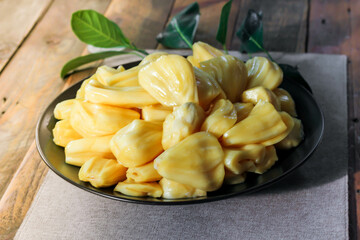 Thai fruit, fresh jackfruit placed in a black plate on a wooden table.