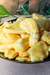 Thai fruit, fresh jackfruit placed in a black plate on a wooden table.