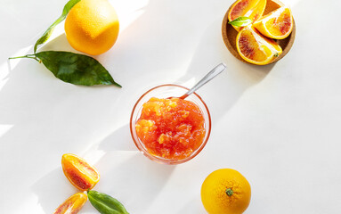 Red oranges' jam in glass bowl with fruits