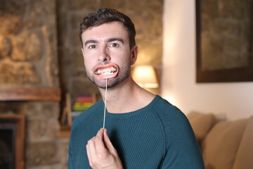 Man putting on a fake smile with metallic brackets