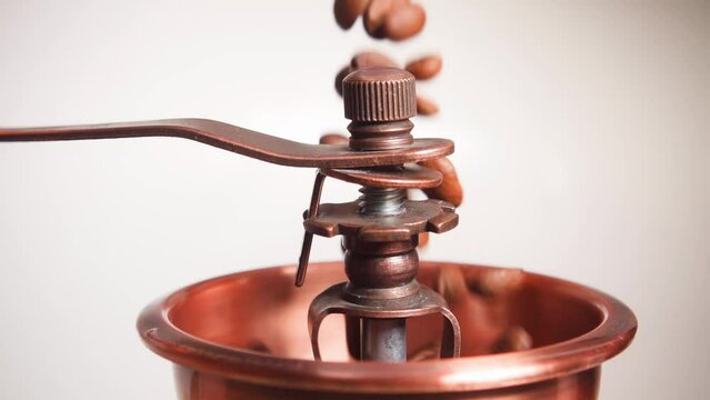 Roasted coffee beans being served in a vintage coffee grinder, slow motion 250 fps
