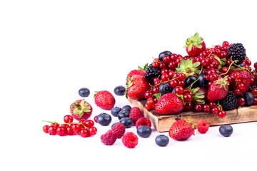 Ripe berries mixed assortment on wooden board on white background. Summer berries background. Cloce up image with copy space.