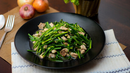 Stir-fried morning glory in a black dish 