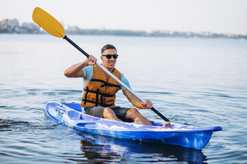 Young man kayaking on the river