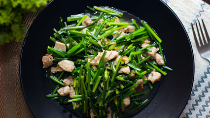 Stir-fried morning glory in a black dish 