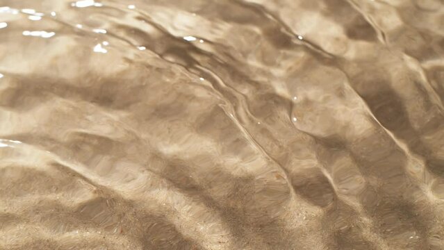 Super slow motion of water waves with sand texture. Filmed on high speed cinema camera, 1000 fps.