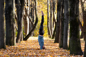 Sporty man practicing yoga in autumn park