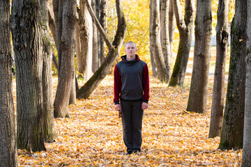 Sporty man walking in autumn park 