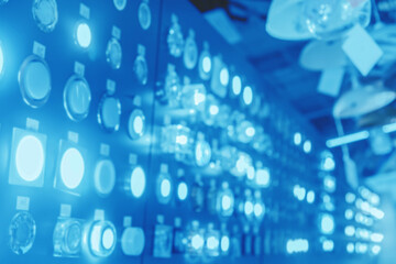 Blurry cold blue unsharp abstract shiny background of glowing light bulbs and lamps in the store