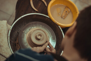 A man working on a potter's wheel. Creative work with clay.