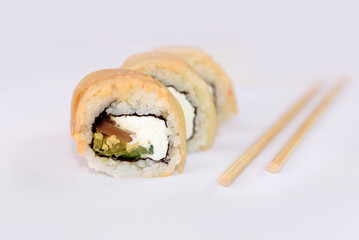Close up of sushi and chopsticks for sushi on a white
