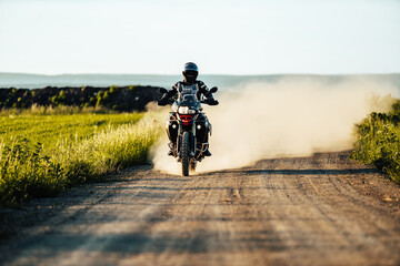 person riding a bike on a dirt road with a cloud of dust behind