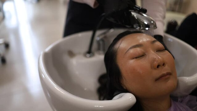 Hair coloring in the salon, hair styling. Professional wizard paints the hair in the salon. Beauty concept, hair care.