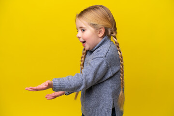 Little caucasian girl isolated on yellow background with surprise facial expression