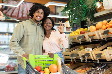 Black Couple Gesturing Okay Doing Grocery Shopping Posing In Supermarket