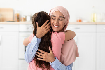 Parent's Affection. Happy Muslim Lady In Hijab Embracing Her Little Daughter, Closeup