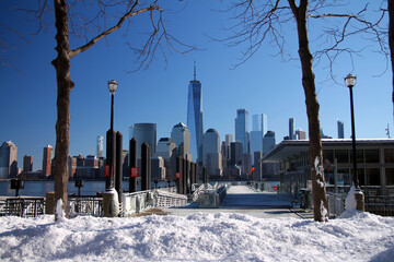 Downtown Manhattan and the Freedom tower with a ferry dock and the snow