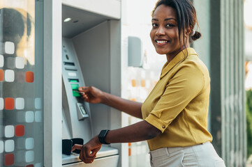 African american woman using an atm machine and a credit card